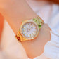 Women’s gold-tone round watch with white dial, rhinestone bezel, and linked bracelet