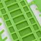 Green cross-stitch thread organizer tool with textured grid and slot openings