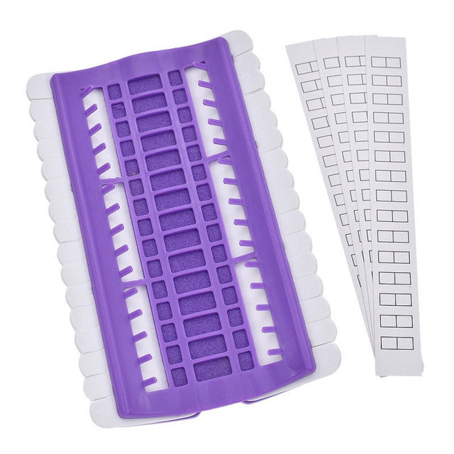 Purple cross-stitch thread organizer tool with slotted grid and white template strip