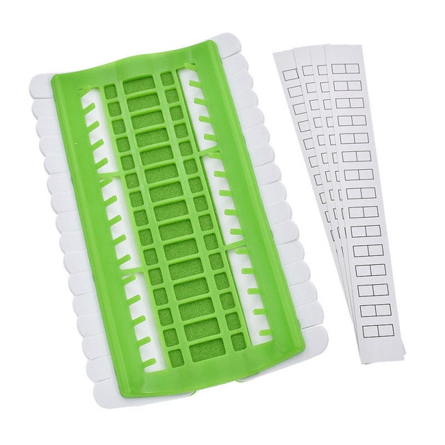Green cross-stitch thread organizer tool with slotted grid and white template strip