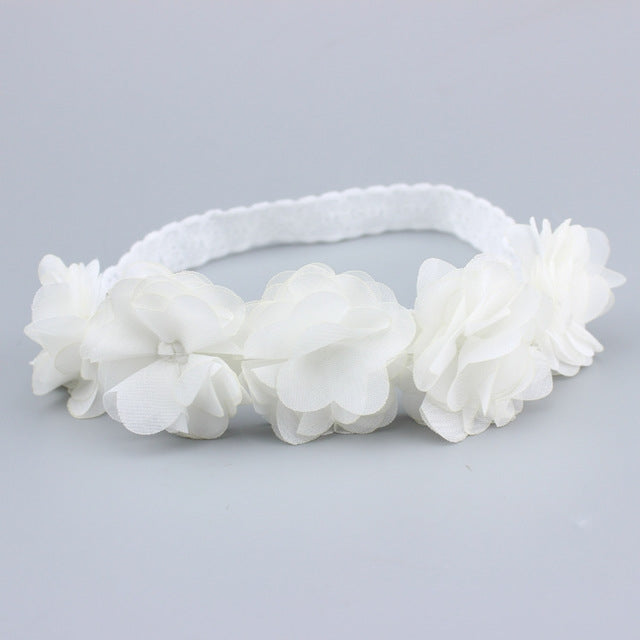 White baby flower headband with three large rosette blooms and soft elastic band