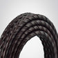 Curved close-up of black braided leather belt showing woven texture