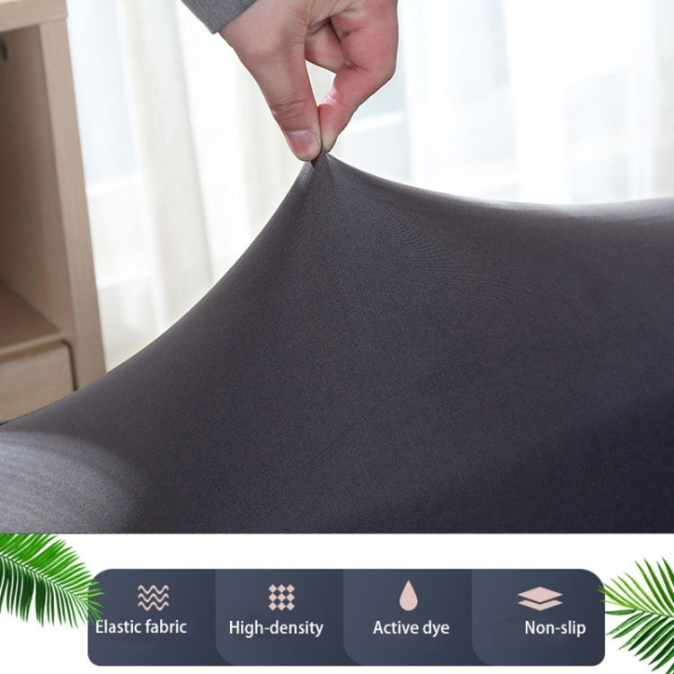 Dark gray sofa cover fabric close-up, hands adjusting the fitted stretch cover