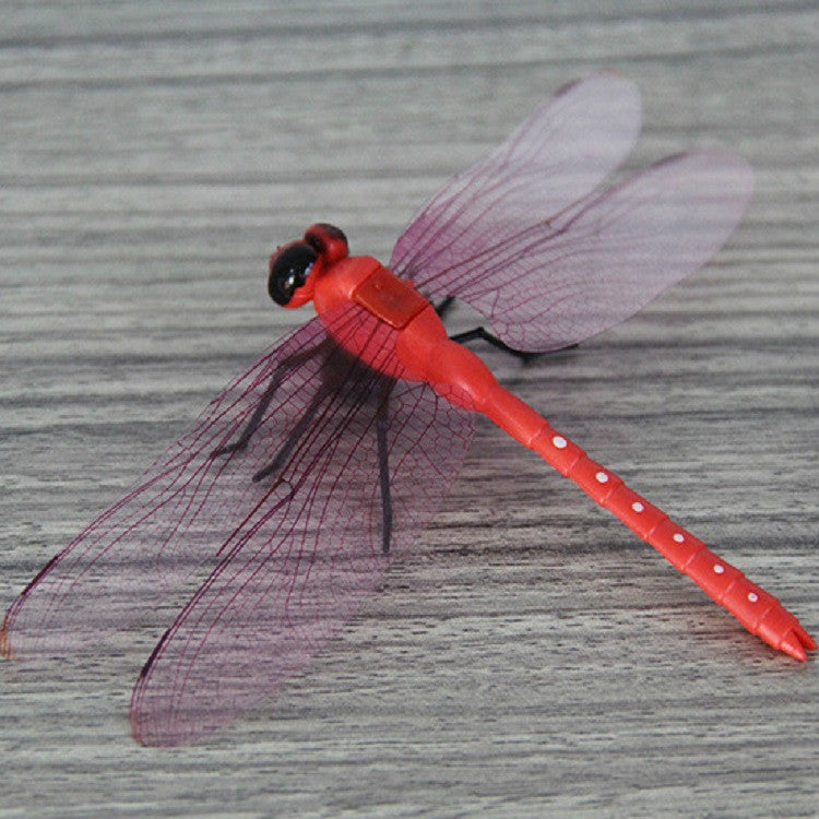 Red dragonfly decoration with translucent wings and textured body, stick-style