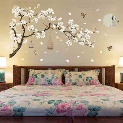 Wall decal tree branch with white blossoms, hanging birdcage ornaments, and small flying birds