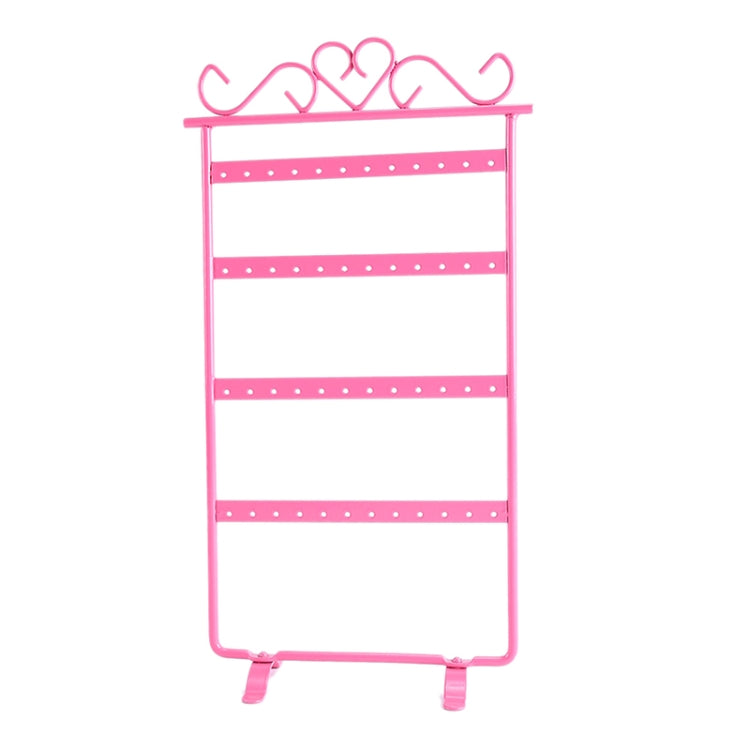 Pink jewelry stand holder rack with four tier bars and curved earring hooks on top.