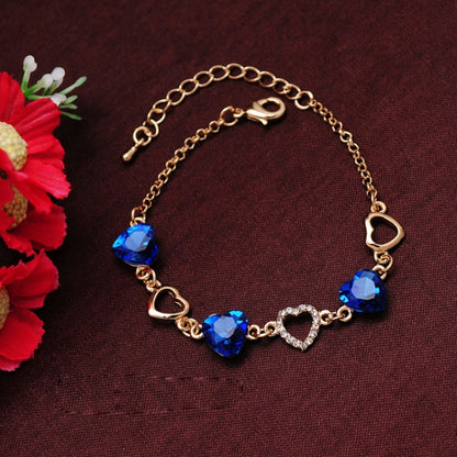 Gold-tone bracelet with blue heart crystal charms and small heart links