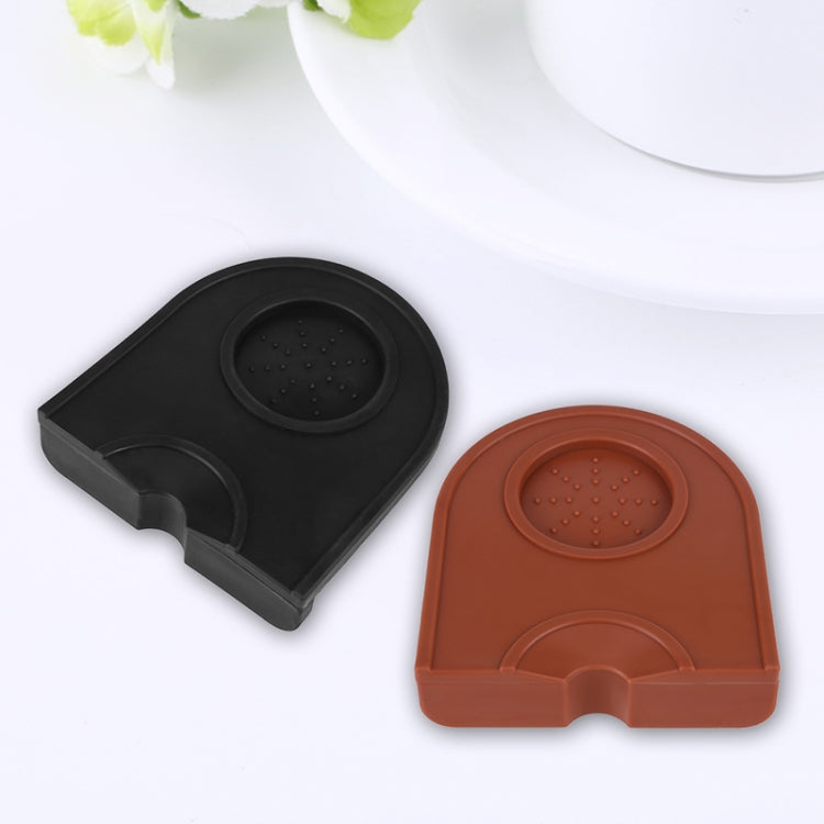 Two corner coffee pads, black and brown/orange, each with embossed round textured center.