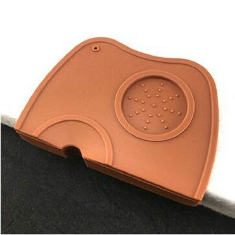 Brown/orange corner coffee pad close-up with round embossed textured insert and front notch.
