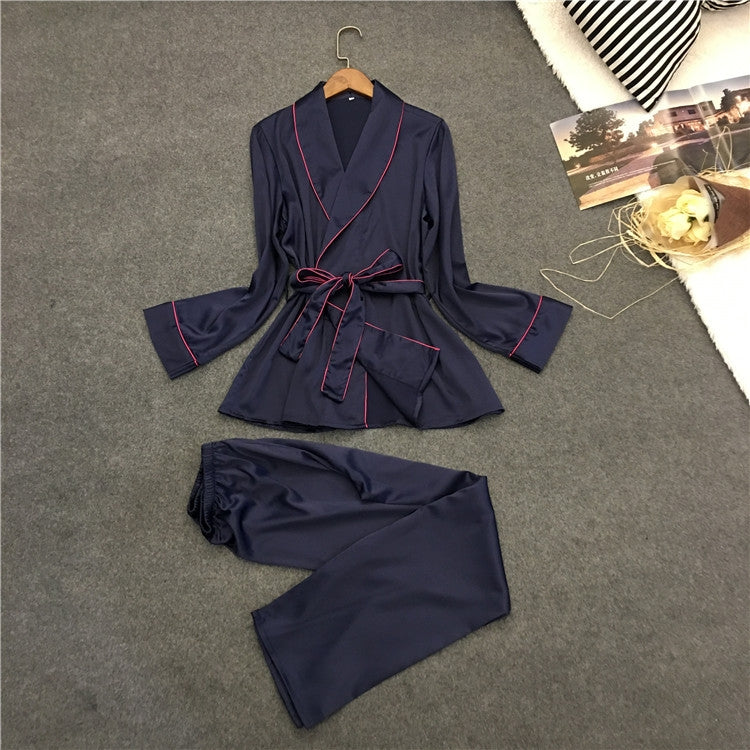 Navy silk-look pajama set with tie-belt robe top, red piping, and wide-leg trousers