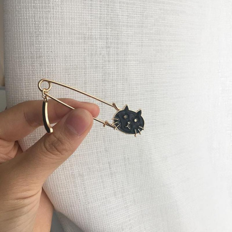 Black cat enamel pin brooch held in hand, gold-toned safety pin backing