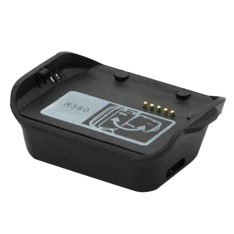 Black charging base cradle with contact pins and side clips, angled view