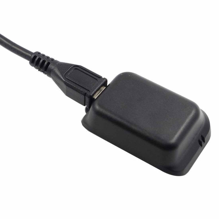 Black USB cable with plug attached to charging cradle housing