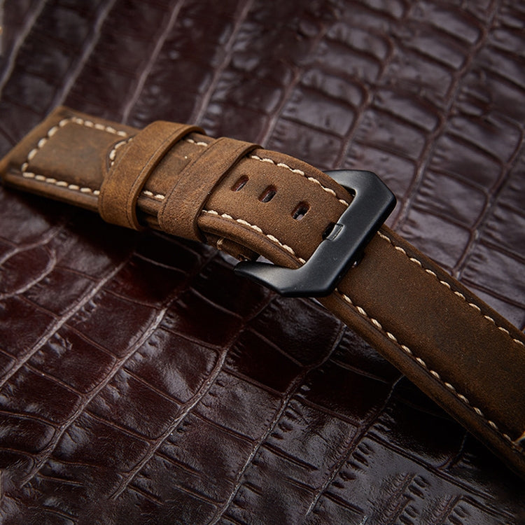 Tan leather watch band with stitched edge and metal buckle on strap.