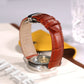 Cognac leather watch band with metal clasp on wrist, stitched crocodile texture