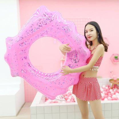 Pink shell-shaped inflatable swimming ring with starfish-like opening and glitter details