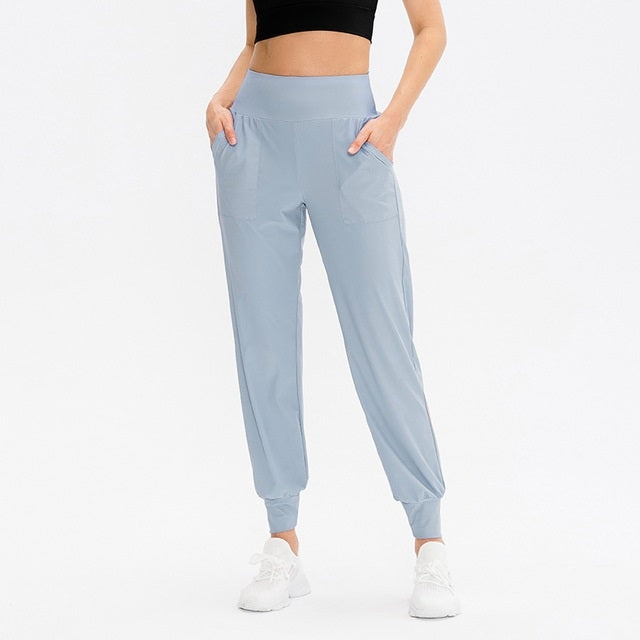Women’s loose sports trousers, light blue, elastic waistband, side pockets, jogger cuffs