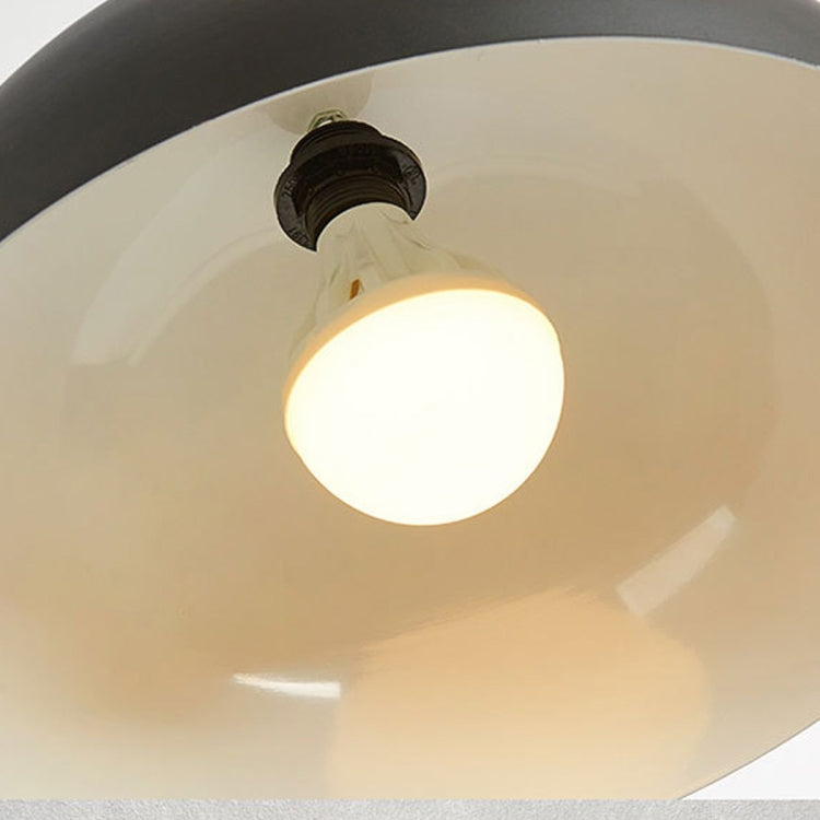 Black pendant light with illuminated bulb inside the metal dome shade