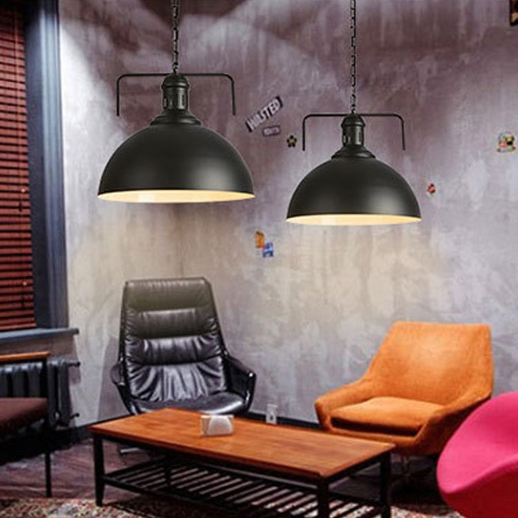 Black single-head pendant lights with dome shades hanging from metal chains