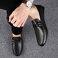 Men's black leather loafers with round toe and adjustable strap, worn with pants
