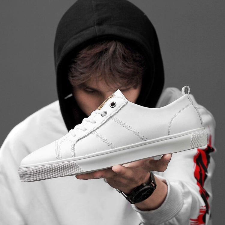 Men's white low-top lace-up sneakers shown on hand, leather-look upper and rubber sole