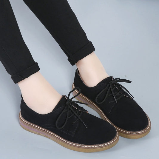 Women's black suede lace-up flats shown from the side with tan stitched sole