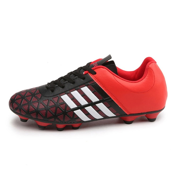 Red soccer cleats with black laces, white striped accents, and textured outsole studs