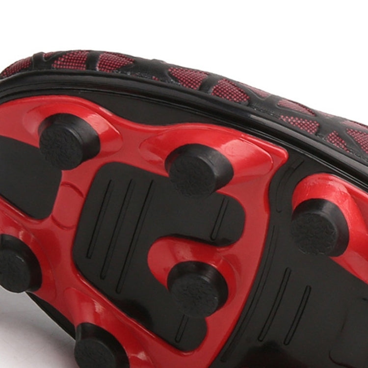 Close-up of red and black cleat outsole with molded traction studs and pattern