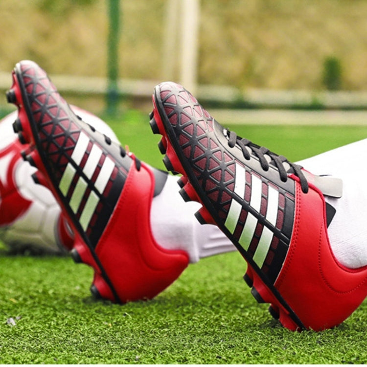 Red and black soccer shoes with black laces, striped sides, and studded outsole