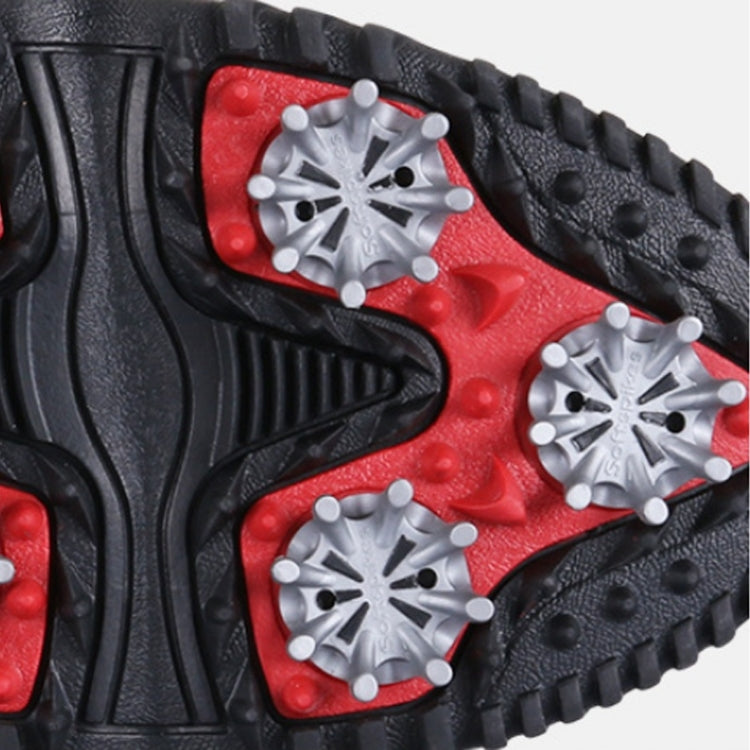 Golf sneaker outsole close-up with red insert, silver studs, and deep tread traction
