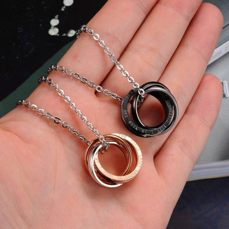 Black and rose gold interlocking ring couple necklaces in hand on silver chains