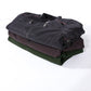 Stack of men's leather jackets in assorted dark and green tones, folded