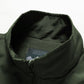 Dark green vest interior with stand collar and neck label close-up