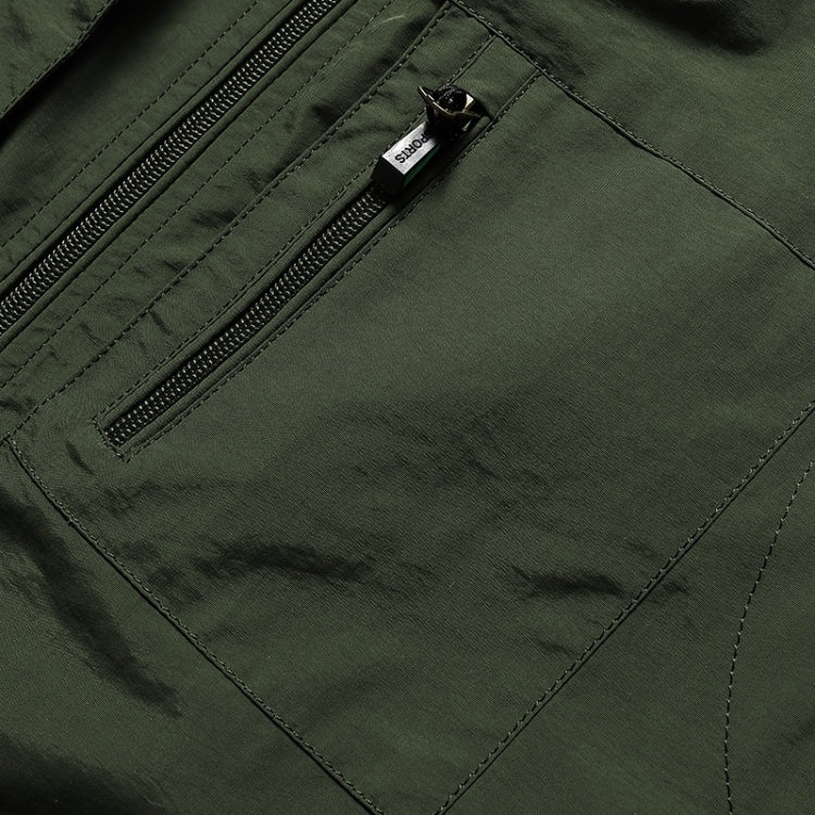 Dark green vest pocket close-up with zipper and brand label