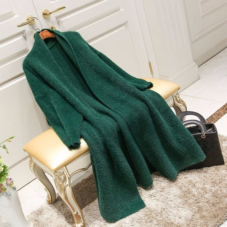 Green knit cardigan sweater draped over a chair
